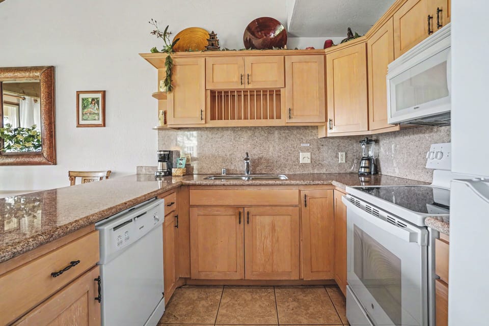 Your fully equipped kitchen awaits with granite counters, modern appliances, and warm wood cabinetry—perfect for preparing meals and gathering during your stay.