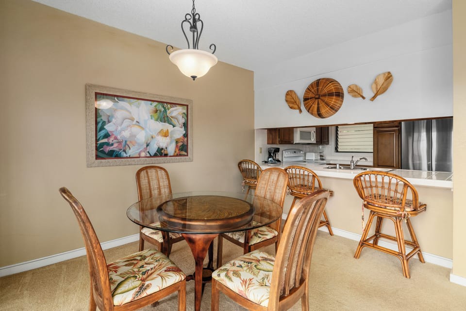 Gather around the elegant dining table where tropical-inspired decor and an open kitchen create the perfect spot for your morning coffee or evening meals together.