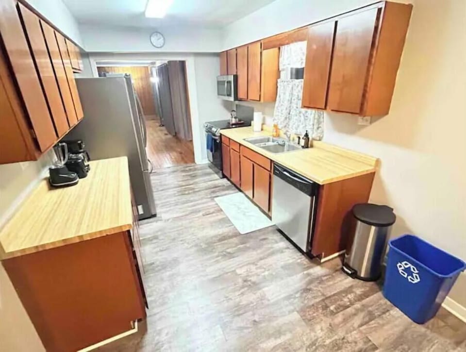 Kitchen with appliances, cookware, coffee, creamer, sugar & dish pods.
