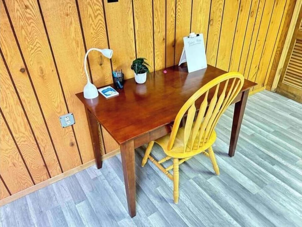 Basement workspace with desk, lamp, and basic office supplies.