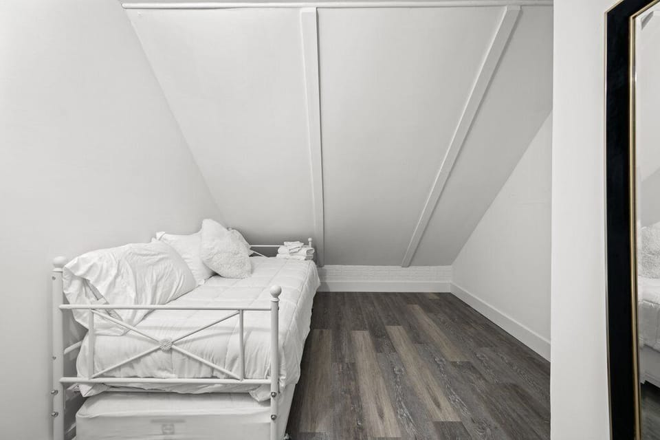 Another angle of the cozy space with metal frame and white bedding.
