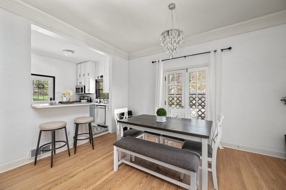 Bright kitchen with white cabinets, stainless steel appliances, and island seating.