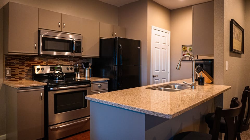 Well-appointed kitchen with granite countertops standard-sized fridge/freezer, stove, oven, microwave, dishwasher, and Bunn coffee maker and grinder.