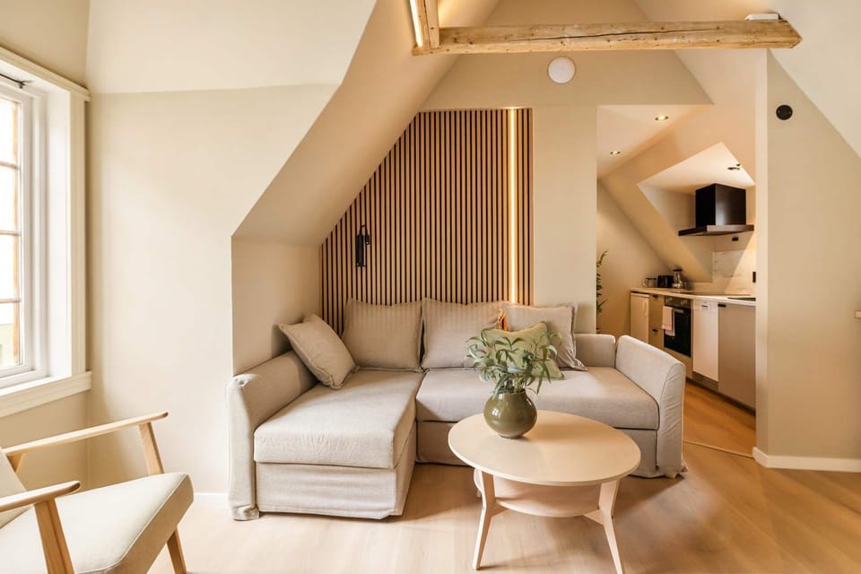 Bright living area with comfortable sofa and glimpse of the well-equipped kitchen beyond