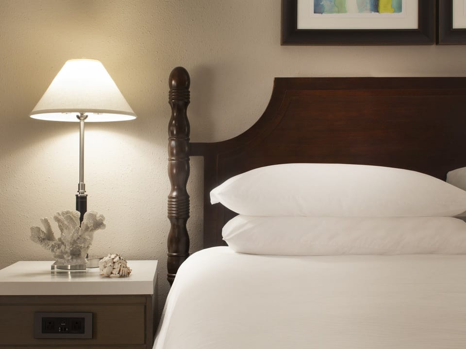 Drift off beside warm lamplight and plush, layered pillows.