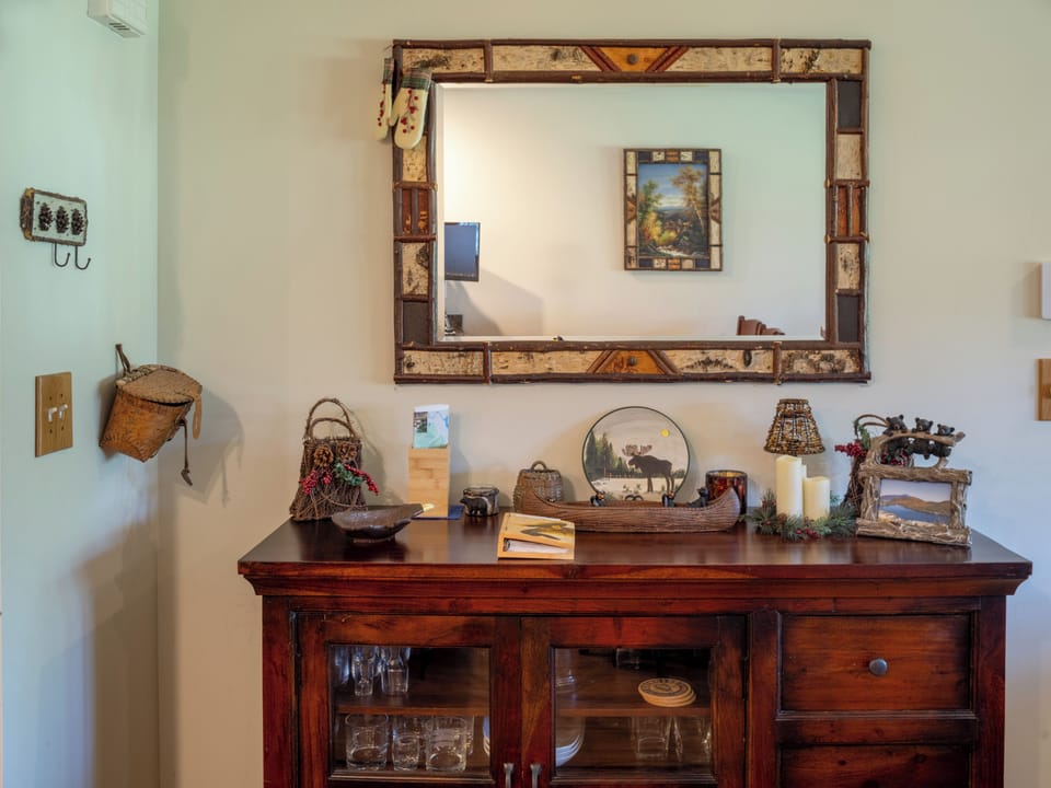 A cabinet for glasses plus a beautiful birch mirror, with ADK decor throughout!