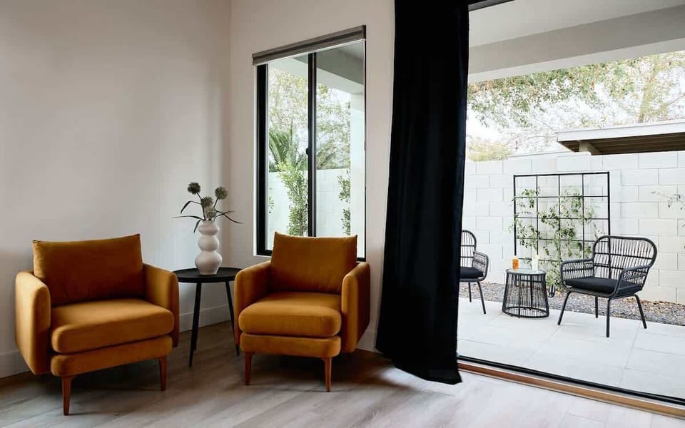 (1st Floor) Primary Bedroom with  King bed, smart TV, lounging space, designer decor, access to the patio, and en-suite bathroom.