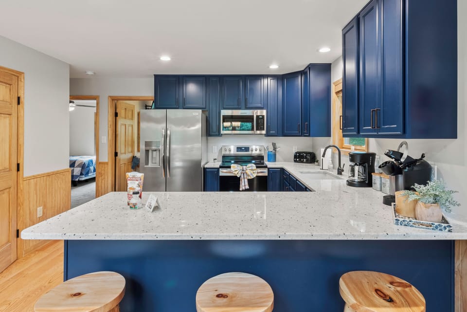 Gorgeous blue cabinetry and barstool seating in the kitchen area.