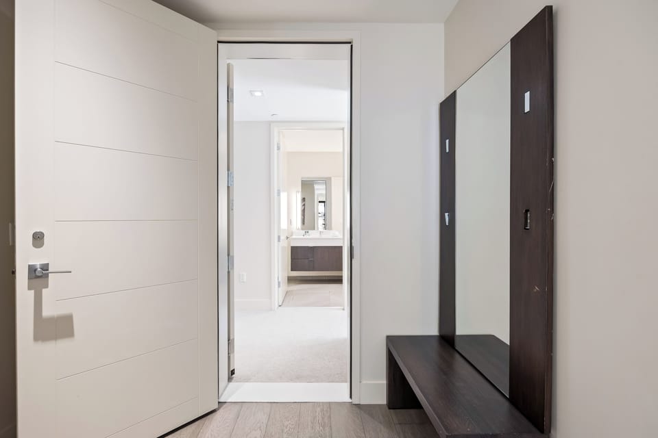 - Entryway with bench and full mirror for ski gear and coats  
- Modern hallway leads directly into spacious ensuite bathroom  
- Convenient setup for organizing essentials during ski trips