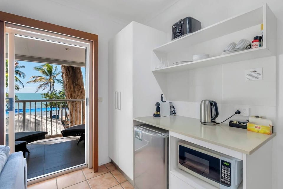 Compact and functional, the kitchenette is equipped with essentials including a microwave, mini-fridge, and coffee maker—perfect for preparing light meals or enjoying a morning coffee before heading to the beach.
