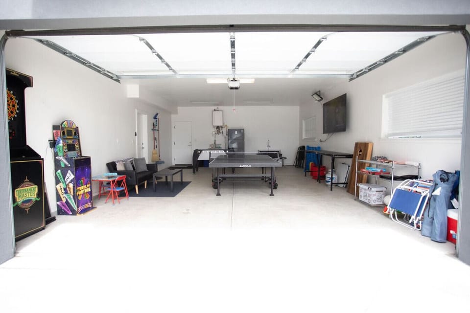 Game room with ping pong, foosball, dart board, arcade games, smart TV, beer pong & futon.