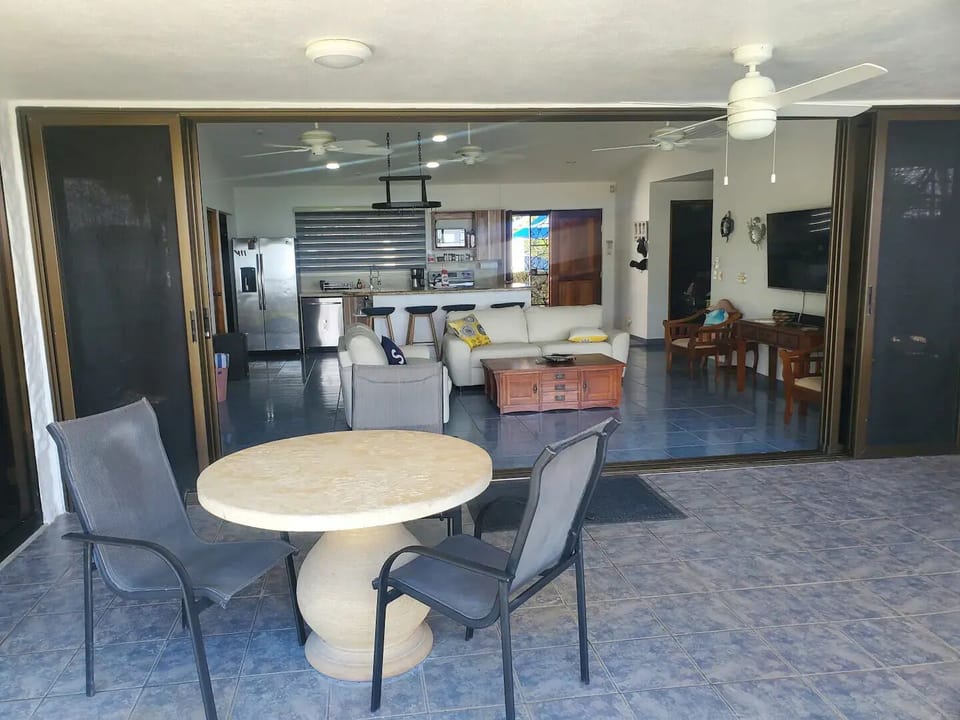 Living room and kitchen showing breakfast bar and island in the background.