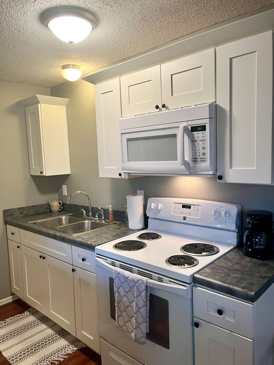Kitchen with drip coffee pot, utensils, basic cooking needs and refrigerator.
