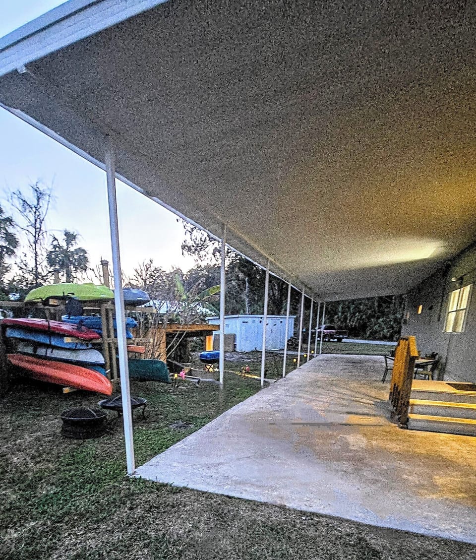 Outside area, kayak rack on left, wall down to canal on right of kayaks