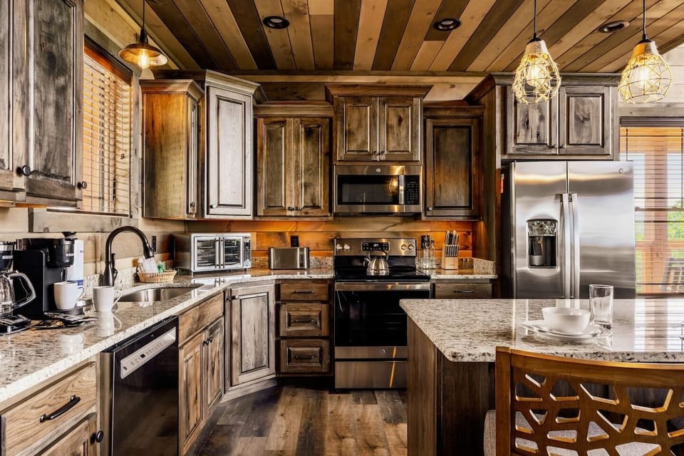 Fully equipped kitchen with custom hardwood cabinetry and an island with seating.  Bear Mountain Vista cabin.