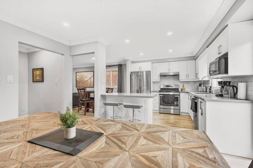 Cook, dine, and connect in this bright, open-concept space. The fully equipped kitchen, with its sleek stainless steel appliances and ample counter space, makes meal prep a joy. Enjoy a quick bite at the breakfast bar or gather around the unique patterned