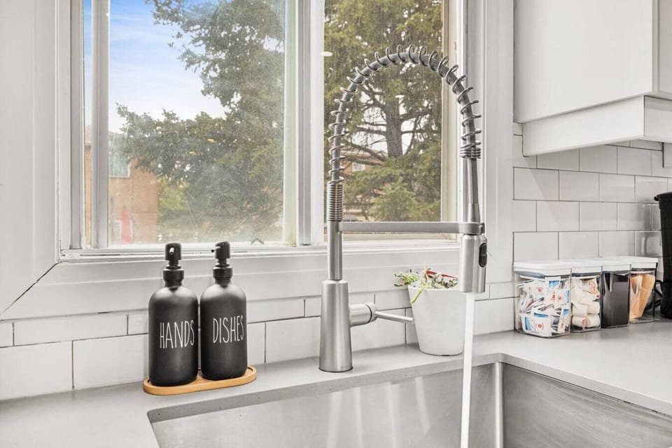 Enjoy modern convenience in the heart of the kitchen. The large sink, featuring a stylish gooseneck faucet, is perfect for easy cleanup. Natural light streams in through the large window, making the space feel open and bright as you prepare meals.