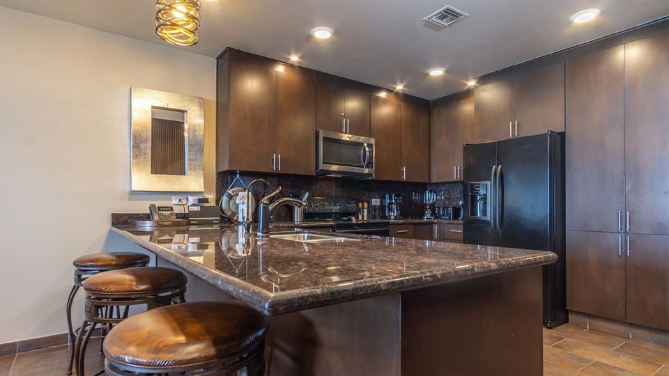 The kitchen with its large counter and many cabinets