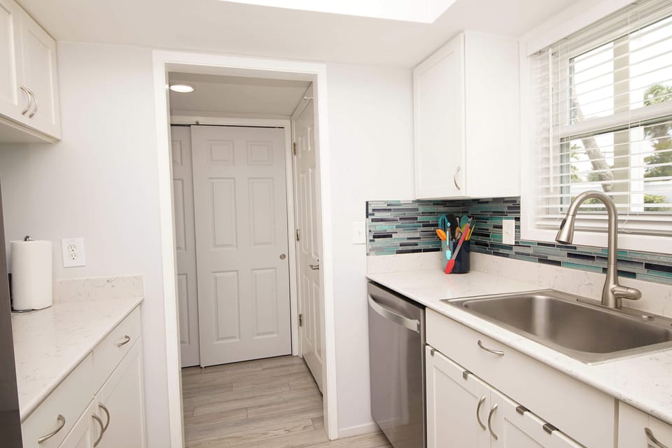 Your bright, modern kitchen awaits with pristine counters, colorful backsplash, and everything you need to create memorable meals together.