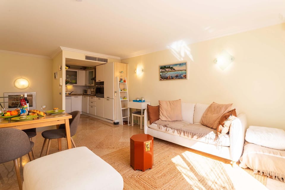 Bright living-dining area with a fully equipped open kitchen, elegant table, and modern decor. Perfect for family or friends to gather.