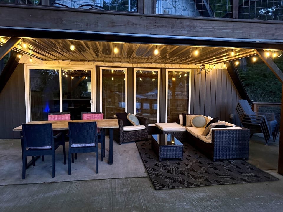 Covered patio with dining, lounge seating, and string lights for relaxing evenings