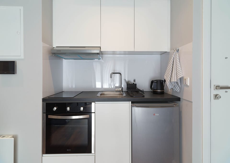 Kitchenette with oven, hob and utensils.