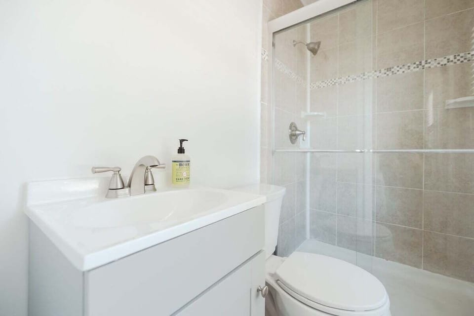 Clean & Modern Full Bathroom with Essentials. Includes shampoo, conditioner, body wash, and fresh towels.