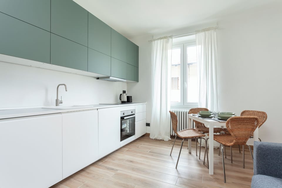 Kitchen with an oven, stovetop, kettle and French Press. 