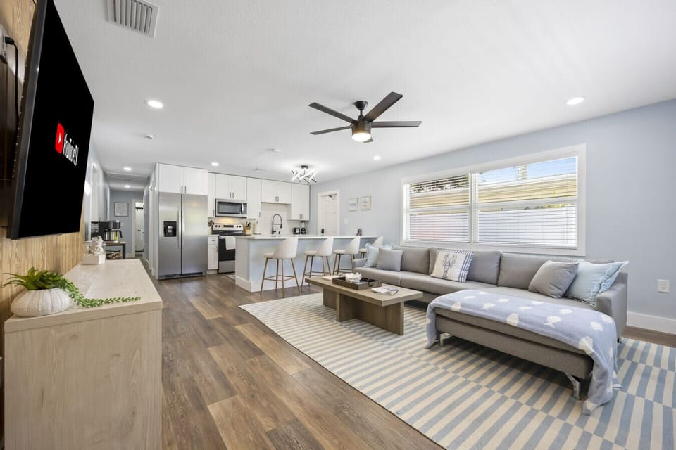 Cocoa Beach living space with a striped rug, breakfast bar and sectional lounge—styled for breezy flow and relaxed coastal ease.