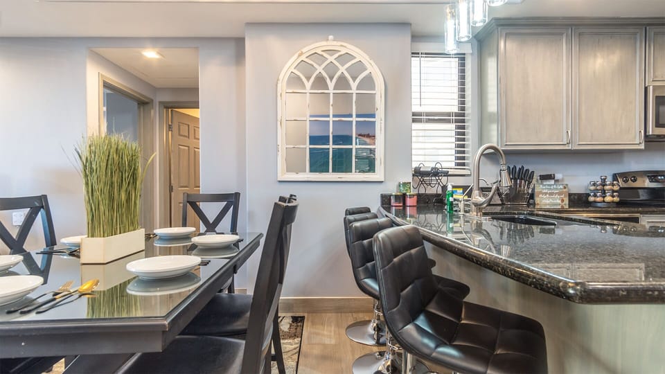 The dining table and the upholstered chairs at the kitchen counter
