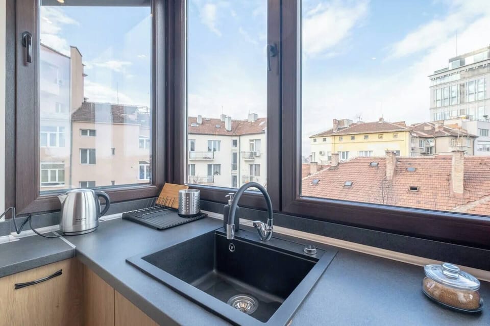 Bright Kitchen with Rooftop Views Cook with a view! This bright and modern kitchen offers everything you need for a pleasant stay, from appliances to panoramic city views. Stay in comfort and style in downtown Sofia – affordable rates starting from €35!