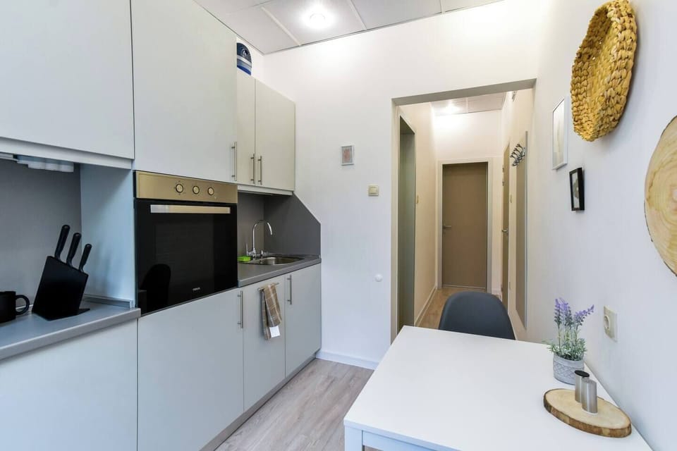 The fully equipped kitchen includes all modern appliances, from a stovetop and oven to coffee/tea facilities. It opens into a welcoming hallway, making meal prep and cooking an enjoyable part of your stay.