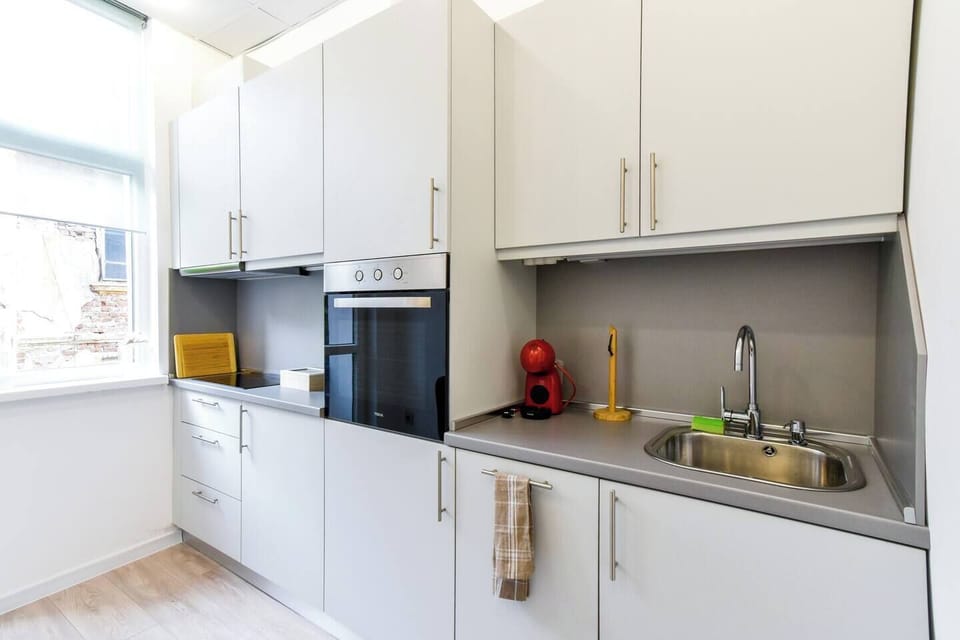 The bathroom offers sleek finishes and elegant decorative touches, including stylish jars and plants that make the space feel like a luxurious retreat. Fresh towels and toiletries are always provided for your convenience.