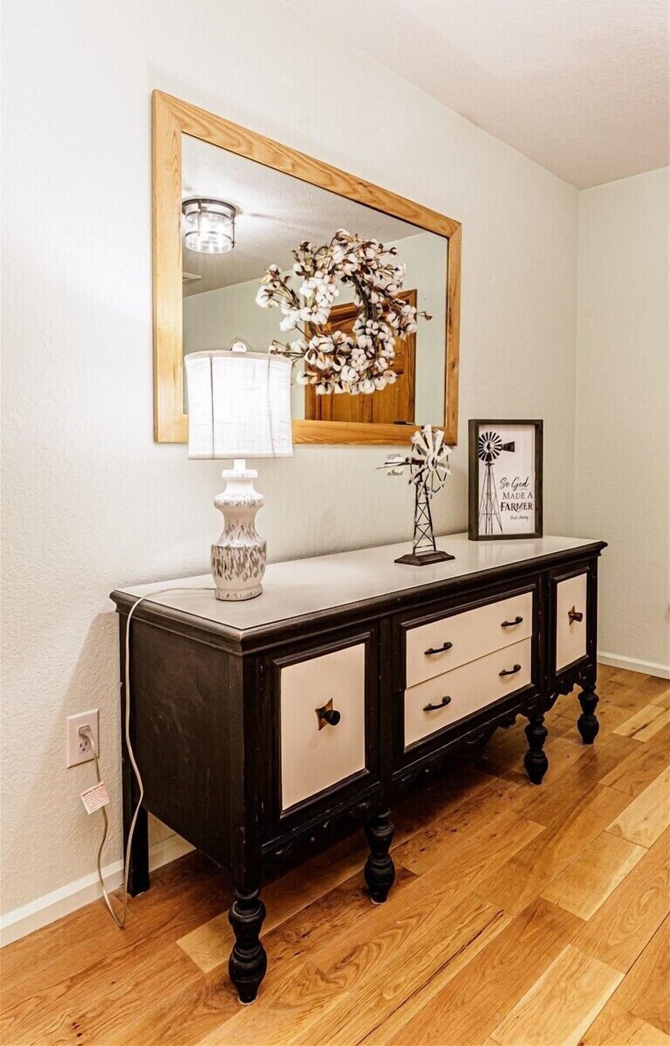 A stylish dark wood dresser with cream-colored drawers and rustic farmhouse decor inside an Alarka Creek mountain retreat.