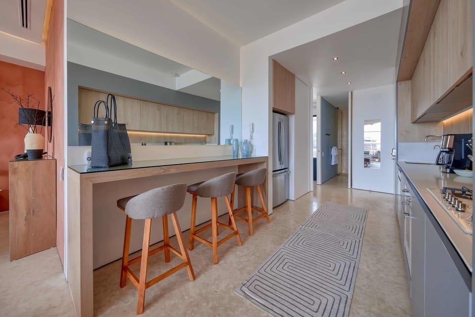 Fully-stocked, modern kitchen with breakfast counter that doubles as an additional workspace with easy access to a variety of power outlets.