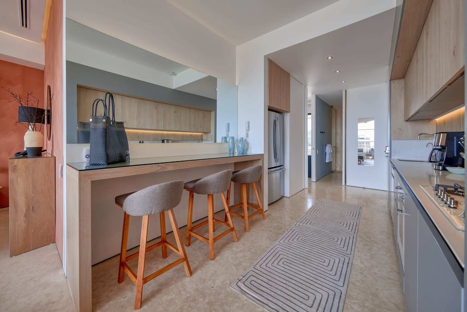 Fully-stocked, modern kitchen with breakfast counter that doubles as an additional workspace with easy access to a variety of power outlets.