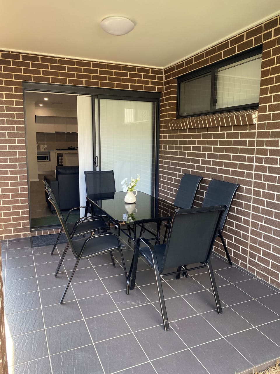 Outdoor alfresco with view of sunny, peaceful and quiet backyard