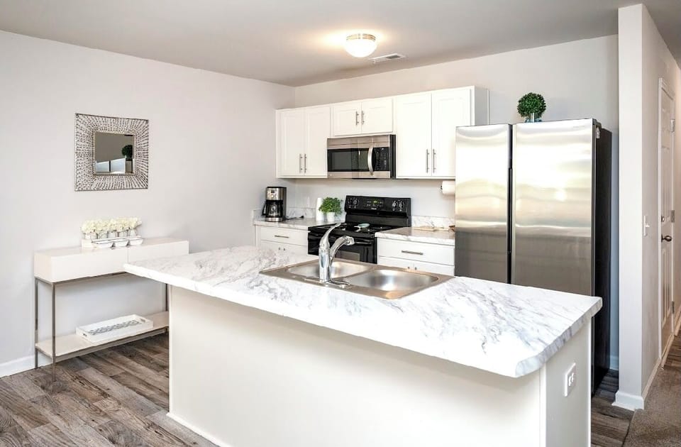 White kitchen with microwave, dishwasher, oven and refrigerator 