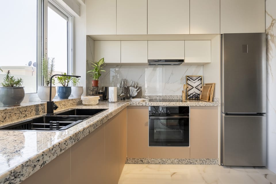 Prepare delicious meals at your convenience in this fully-equipped kitchen featuring stainless steel appliances, granite countertops, and a breakfast bar.