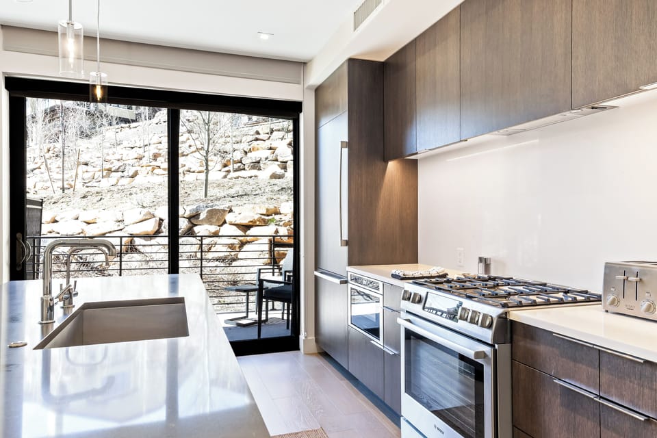 - Let the natural light pour in as you prep meals in this sleek kitchen with mountain views
- Sliding doors open to your private patio, connecting indoor comfort with outdoor calm
- Cook, sip, and savor with stunning rock scape right outside