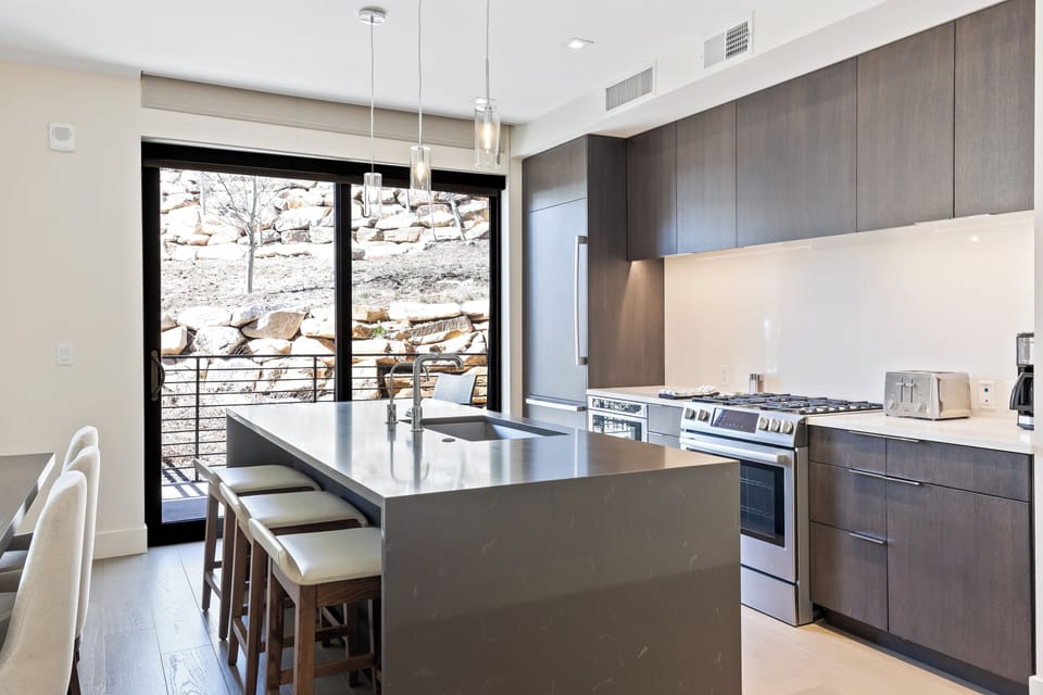 - Cook with a view, sleek island kitchen opens right onto the rocky mountain slope
- Soft pendant lighting, comfy stools, and stainless fixtures create modern warmth
- Ideal for sharing meals, sipping wine, or planning your next trail adventure