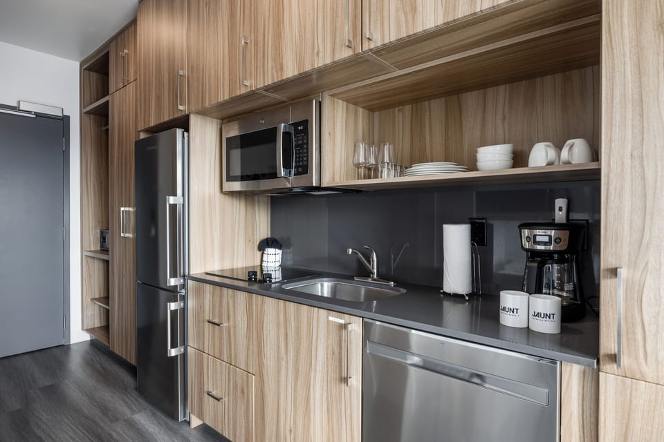 This kitchenette is complete with your daily essentials- Fridge, microwave, coffee maker, dishwasher, cook top and cutleries as well as mugs, glass and cooking pans.