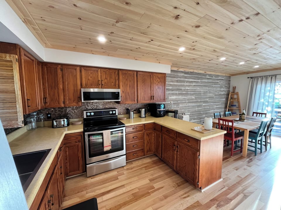 Spacious with ample counter space and wooden cabinetry, designed to make meal preparation a breeze. The modern stainless steel appliances blend seamlessly with the rustic decor.