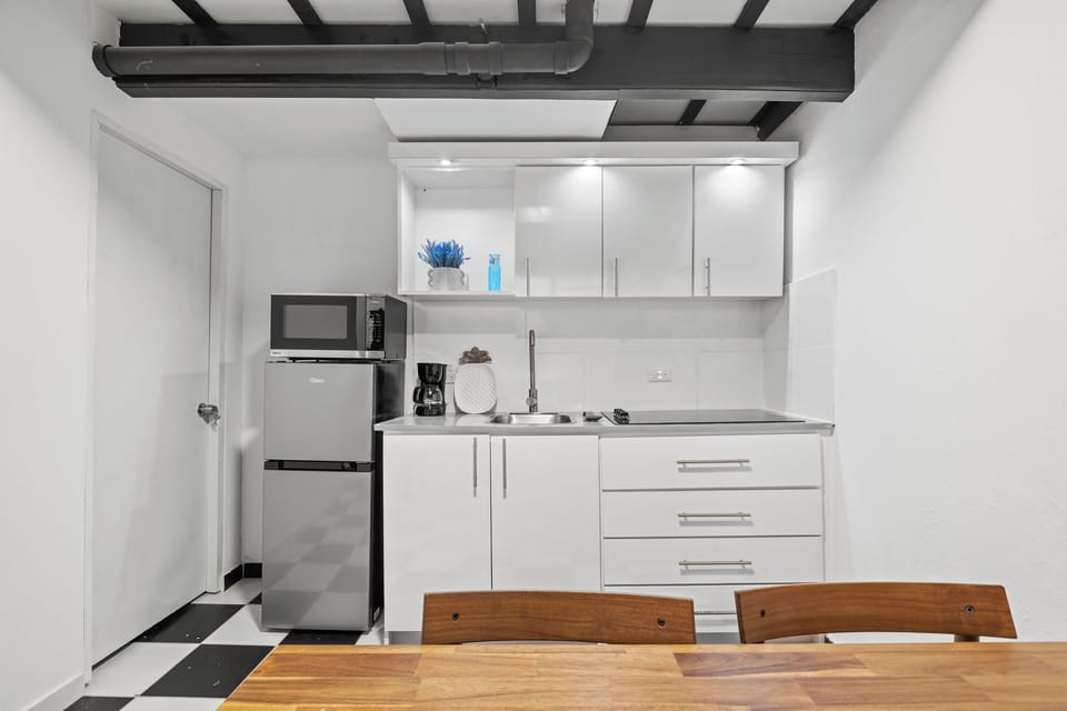The compact but fully equipped kitchen with a mid-size fridge, 4-stove burner, microwave and coffee maker.