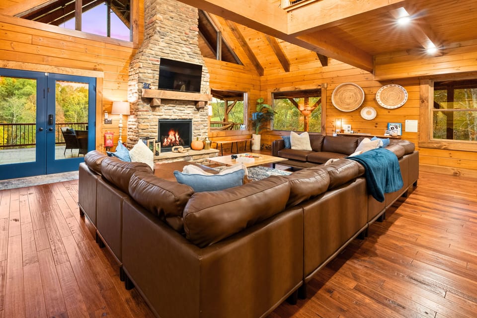 Spacious great room with oversized seating and a stone fireplace — the perfect place for everyone to relax and reconnect after a full day together