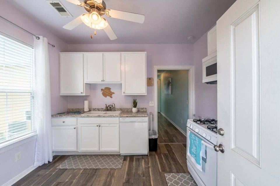 Bright kitchen space featuring modern white cabinets, open layout, updated appliances, and coastal-inspired finishes near Galveston beaches.