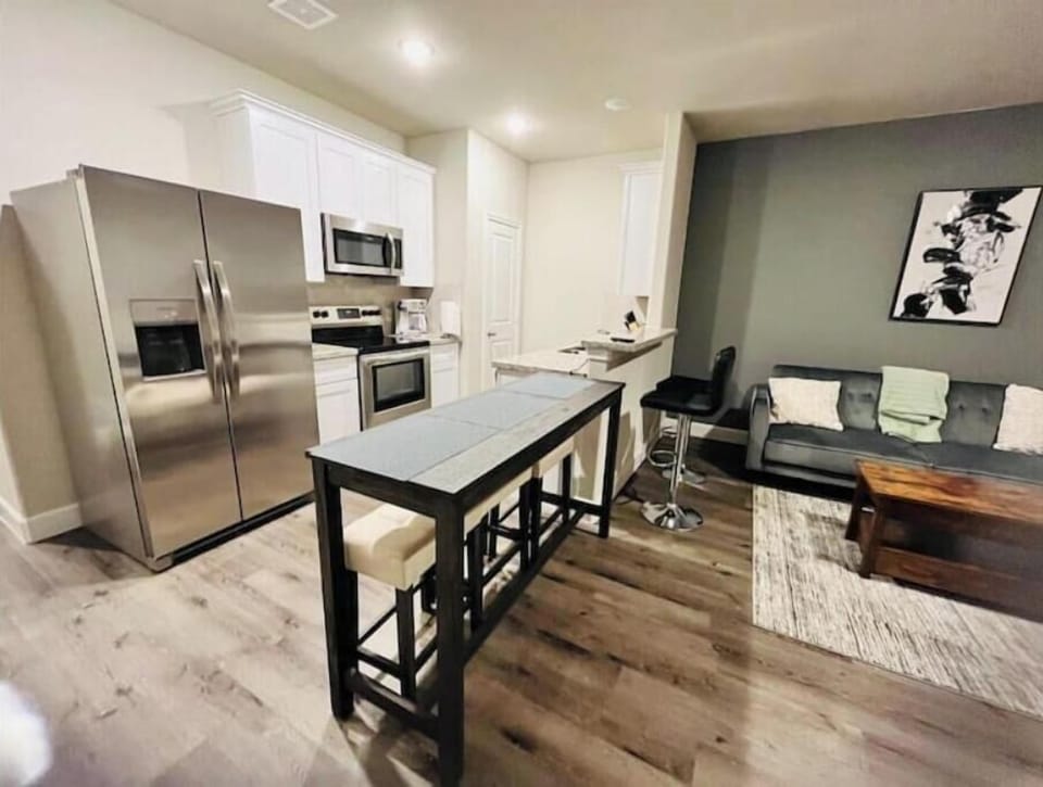 Modern kitchen w/stainless steel.stocked with coffeemaker, tea, water and snacks