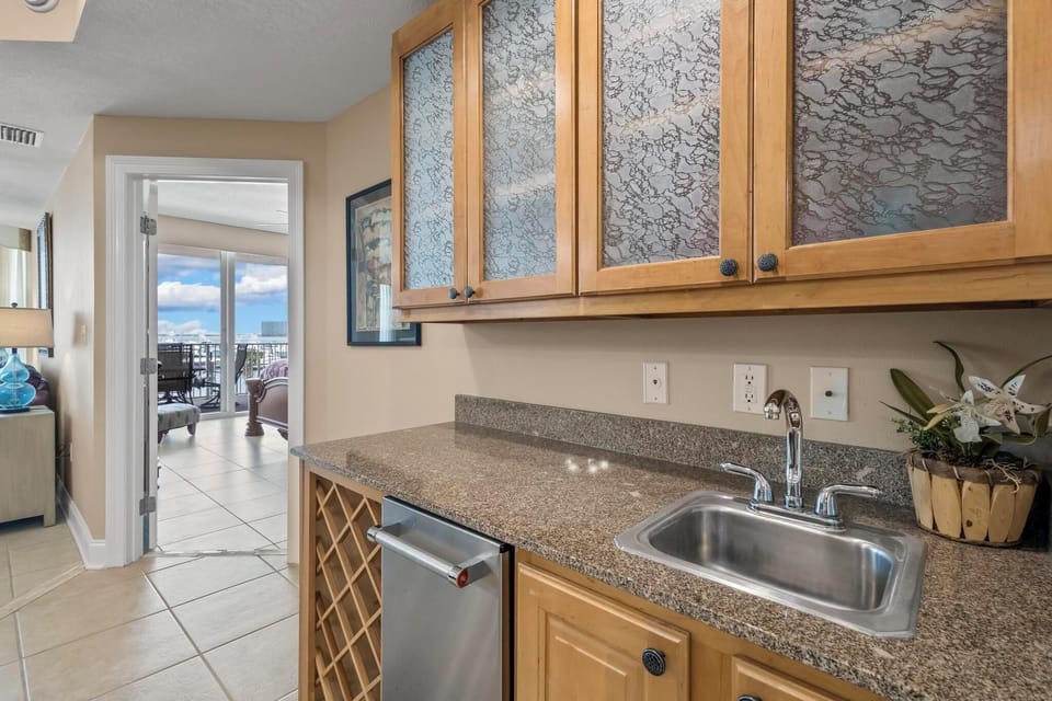 Wet Bar - A wet bar is provided which features an ice maker and beverage sink.