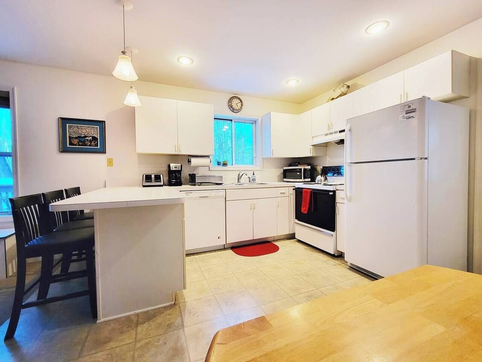 Fully stocked kitchen has refrigerator, electric stove, microwave, dishwasher, toaster, drip coffee maker, blender and more