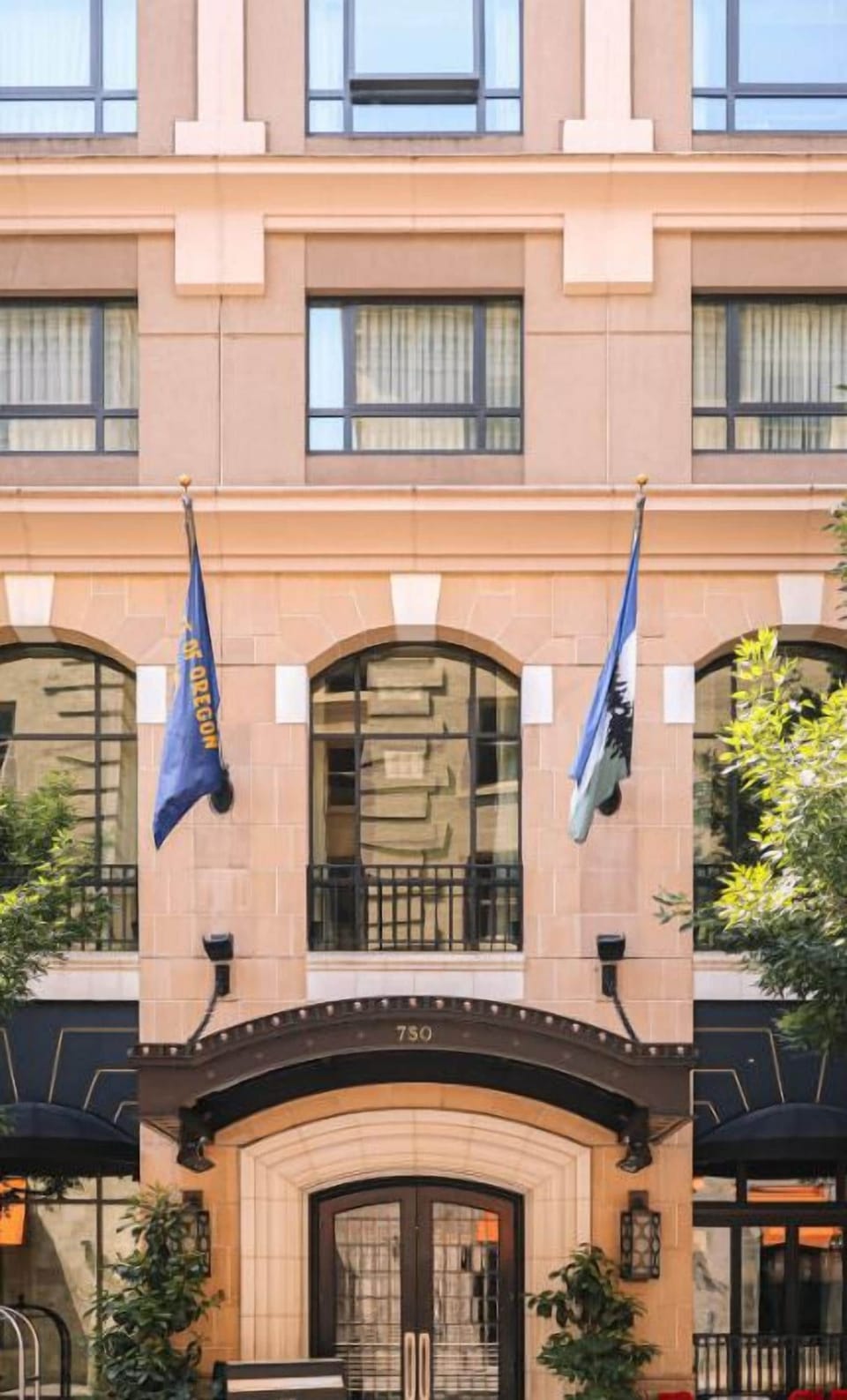 The charming facade of Hotel Dossier, accented with flags, welcomes guests with a promise of exceptional service and a memorable visit.